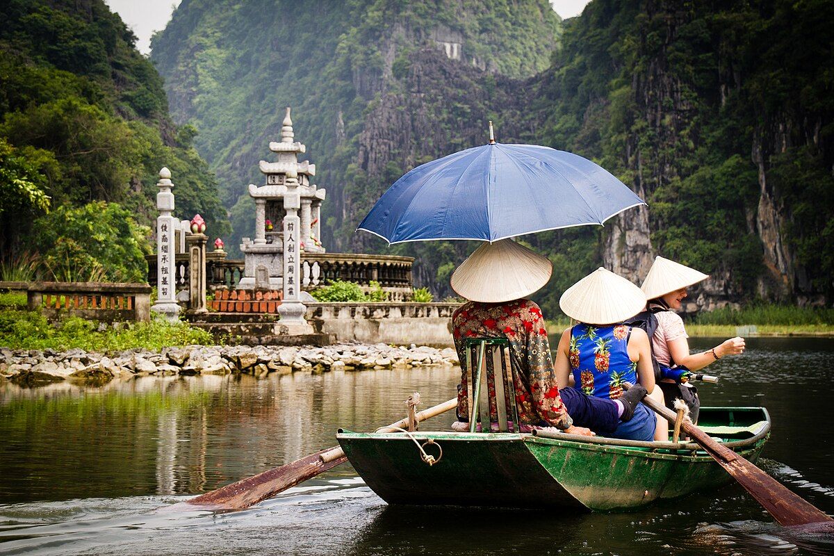 Thuyền chở khách đội nón lá trên sông ở Tam Cốc, Ninh Bình